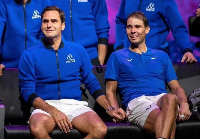 Roger Federer and Rafael Nadal holding hands and sharing an emotional moment together