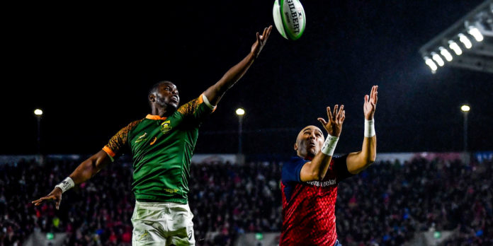 Aphelele Fassi jumping for the Rugby ball, with Muster wing Simon Zebo also contesting