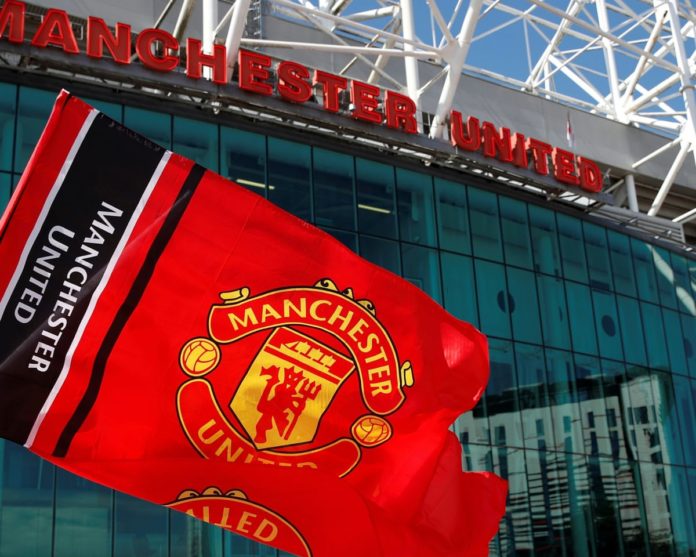 A Manchester United flag in front of Old Trafford.