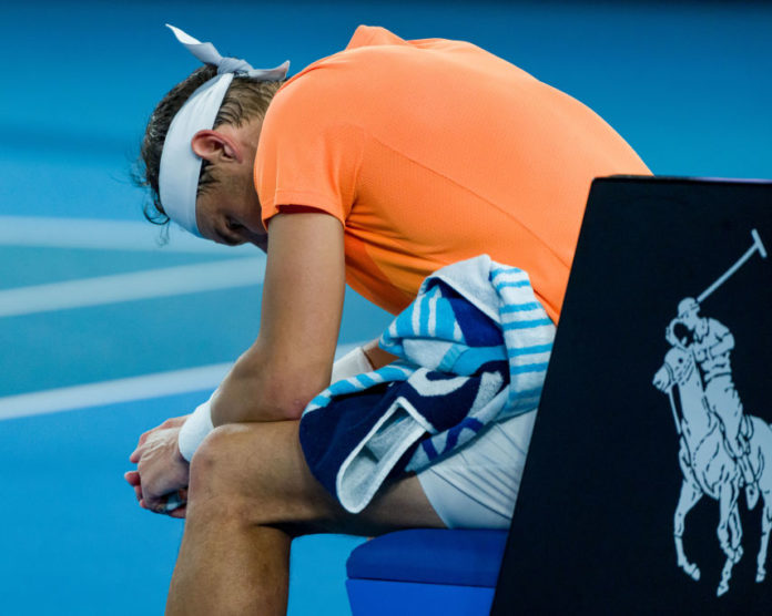 Rafael Nadal slumped over in his chair during is Aus Open match against Mackenzie McDonald.