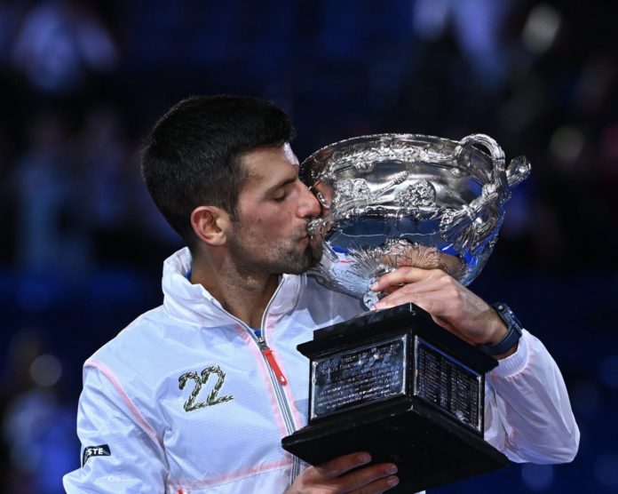 Novak Djokovic kissing his 10th Australian Open trophy