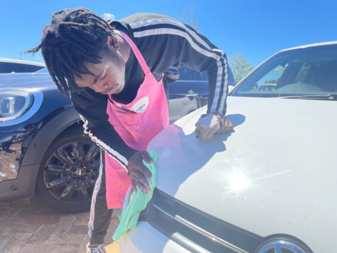 Eric Nkole washing a car