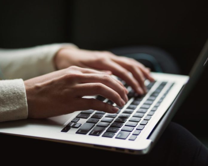 A person typing on a keyboard. Eskom advertises its position for a new CEO