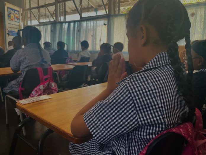 child praying at school