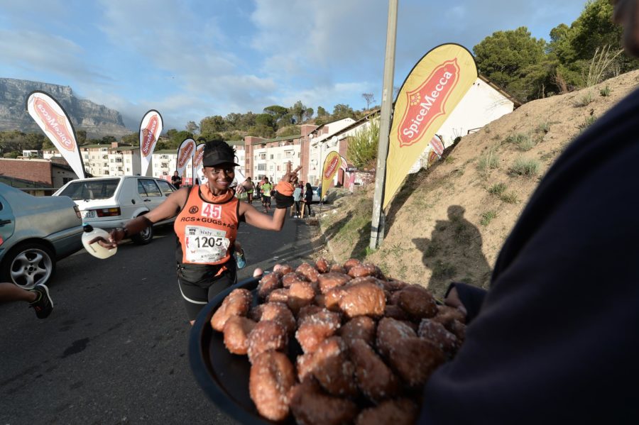 runner taking a koeksister at a race pit stop