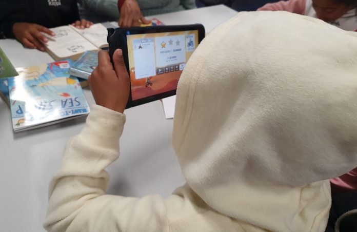 Child plays games on City library tablet