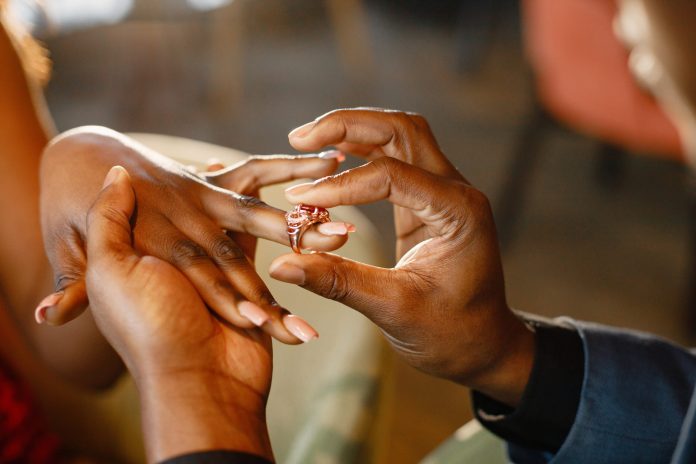 Cropped photo of hands of black man wearing an engagement ring h customary marriage deadline
